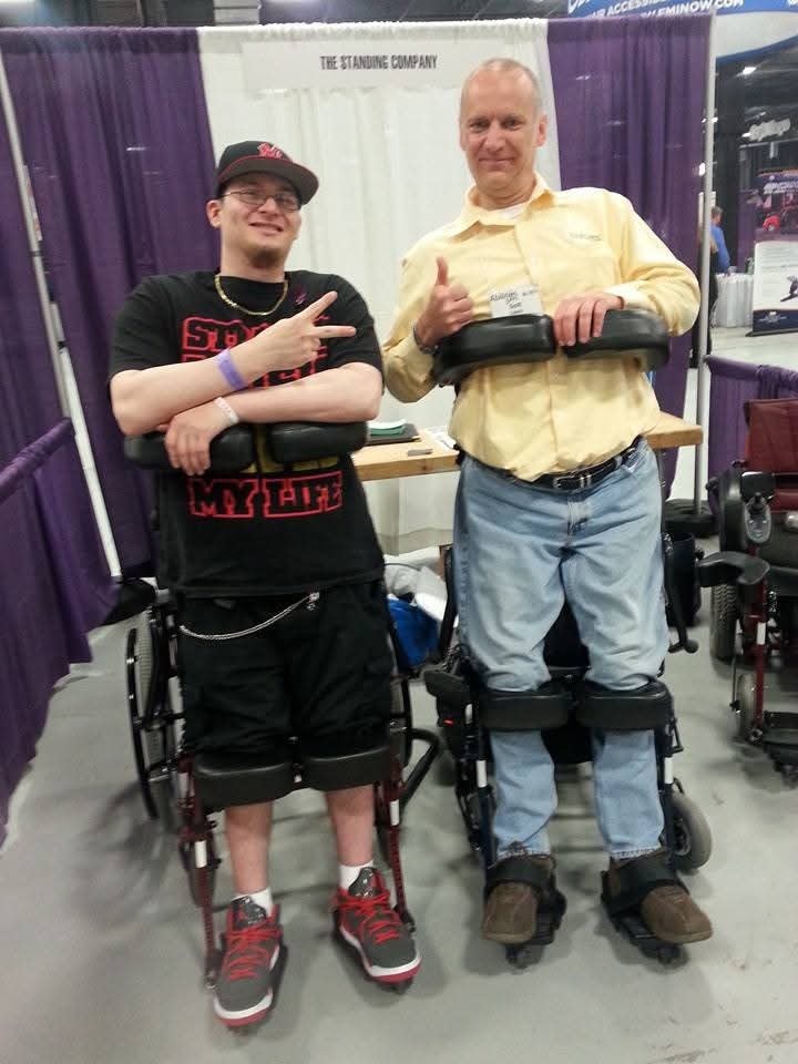 Two members trying standing wheelchairs at expo